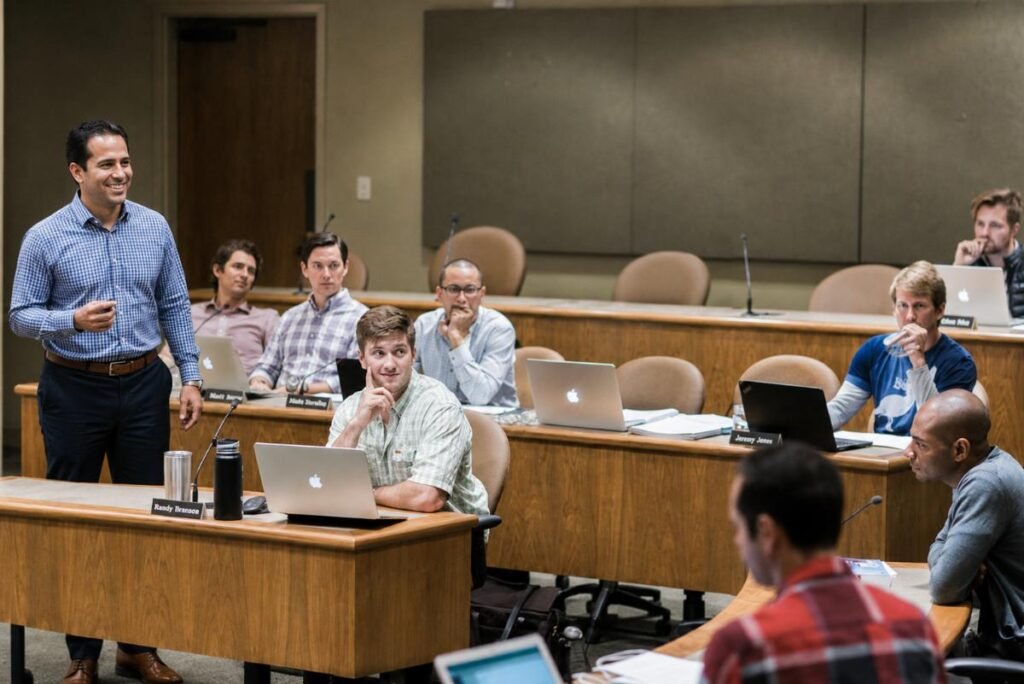 An instructor leads a case discussion in a tiered classroom